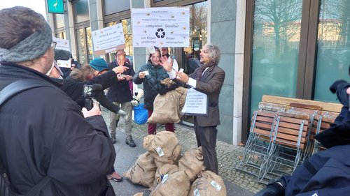 scientists dressed as business men receive bags of fake money