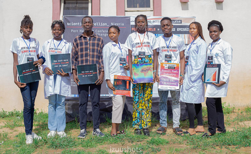 scientists stand together holding various signs