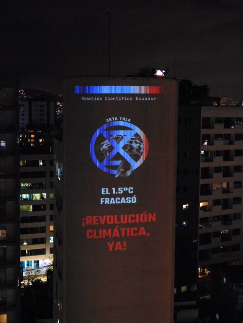 an image saying 1.5 fracasó revolución climática ya is projected onto a high rise building