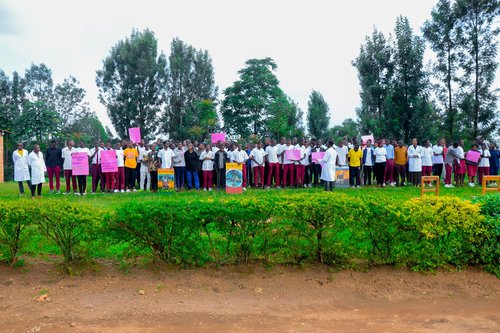hundreds of people stand together holding signs